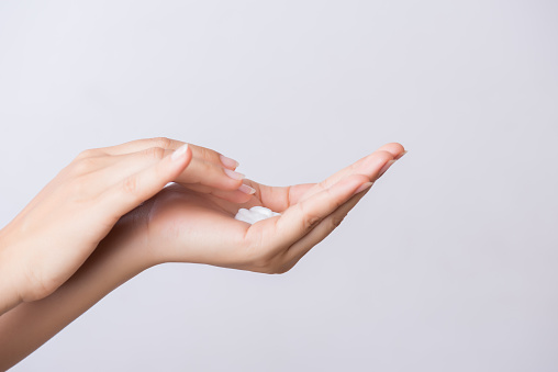 Concepto de salud. Closeup foto de manos de la joven mujer aplicación de crema hidratante para las manos. photo