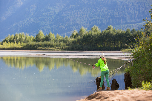 An indigenous Canadian woman standing by the river salmon fishing