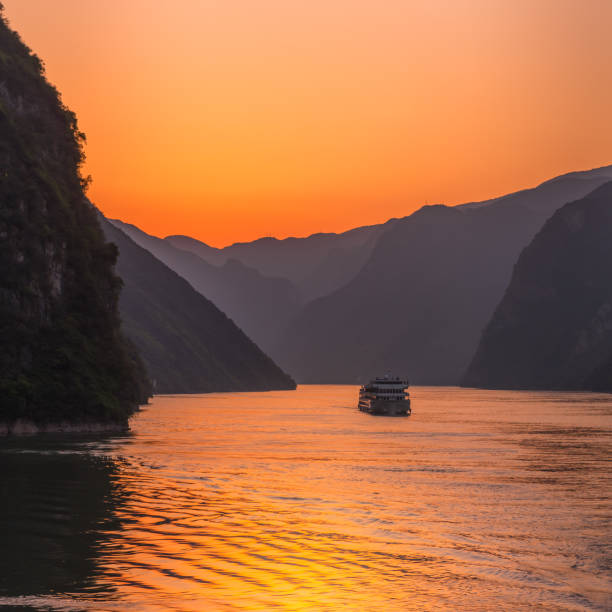Sunset on the Yangtze river dramatic sunset of the Yangtze river with cruise ship in distant foreground three gorges photos stock pictures, royalty-free photos & images
