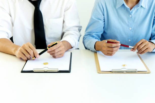 istock man and woman sit at the table to sign 1126032291