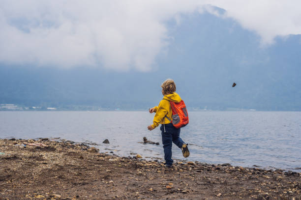 istock Boy at the lake Bratan and the mountains covered with clouds 1126032486