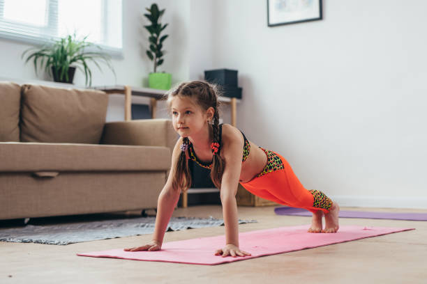 istock Little girl doing plank exercise at home. 1126035454