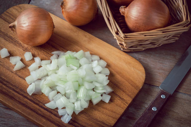 Fresh chopped onions on wooden cutting board Fresh chopped onions on wooden cutting board chopping food stock pictures, royalty-free photos & images