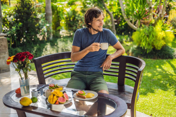 un uomo sta facendo colazione sulla terrazza - 11207 foto e immagini stock