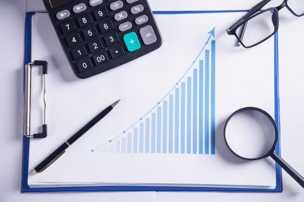 istock Calculator, glasses, magnifier and pen with financial growth graph. 1126046253