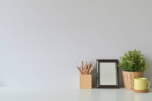 istock pencil, coffee, photo frame and plant on copy space, office desk. 1126046490