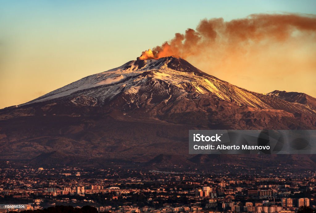 Catania and Mount Etna Volcano in Sicily Italy Mount Etna Volcano with smoke at dawn and the Catania city, Sicily island, Italy, Europe Mt. Etna Stock Photo