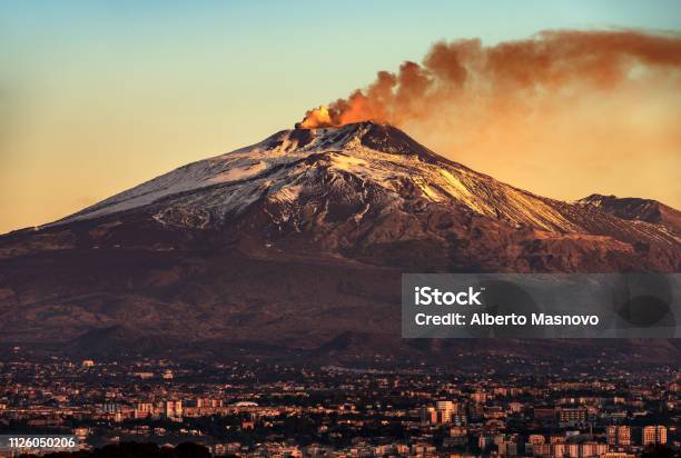 Catania And Mount Etna Volcano In Sicily Italy Stock Photo - Download Image Now - Mt. Etna, Volcano, Erupting