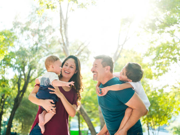 istock Fun latin parents carrying their sons outdoors 1126051263