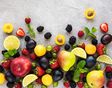 Fresh summer fruits and berries on a concrete background