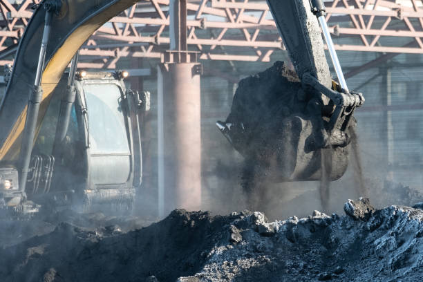 istock Excavator bucket digs a hole in a construction site. 1126056263