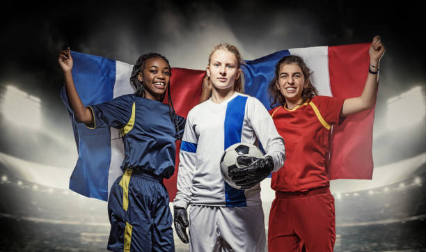 Three Female Soccer Players Three mixed race Female Football Players with a Soccer Ball in front of Stadium Lights soccer team captain stock pictures, royalty-free photos & images