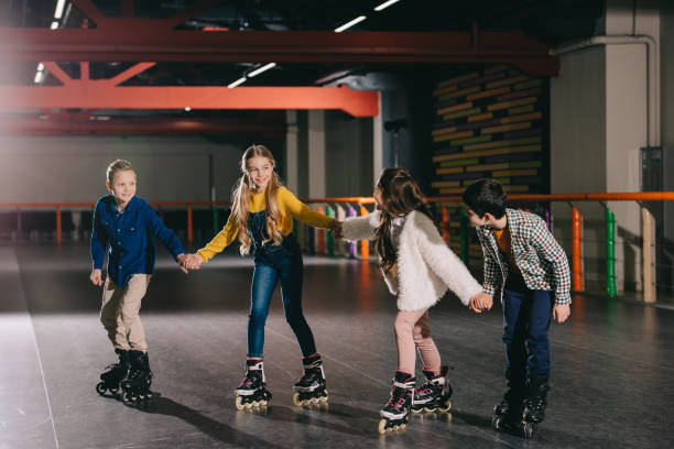 istock Smiling children in roller skating on roller rink and holding hands 1126058482