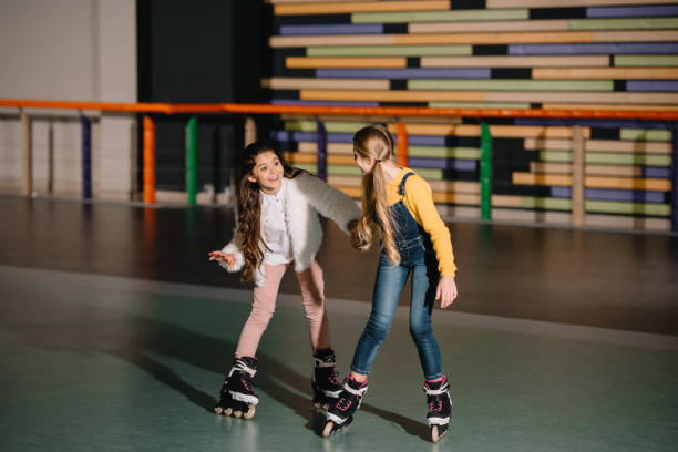 istock Two smiling long haired friends preparing to start moving on roller skates 1126058522