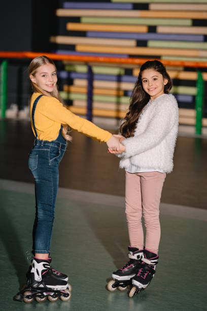 istock Selective focus of beautiful children on roller skates smiling and holding hands 1126058545