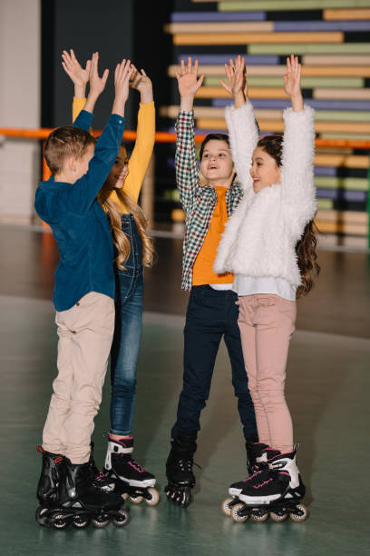 istock Pretty smiling children in roller skates standing with hands up 1126058557