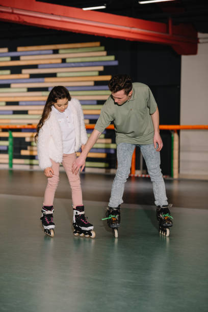 istock Handsome young trainer giving skating instructions to cute long haired child 1126058570