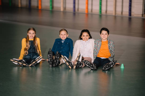 Group of kids in roller skates smiling at camera Group of kids in roller skates smiling at camera roller rink stock pictures, royalty-free photos & images