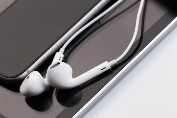 istock white earphones on tablet and phone 1126063095
