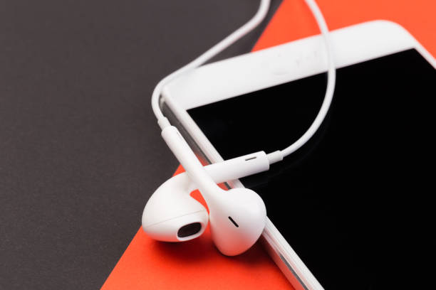 istock white earphones with phone on black  and red background 1126063114