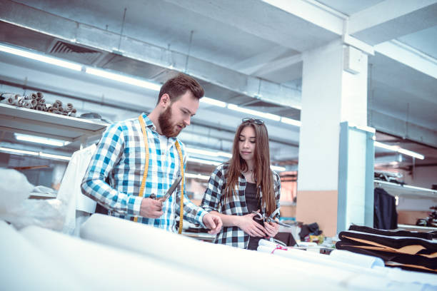 istock Chief Tailor Showing Cutting Techniques To a Cute Female Apprentices 1126063207