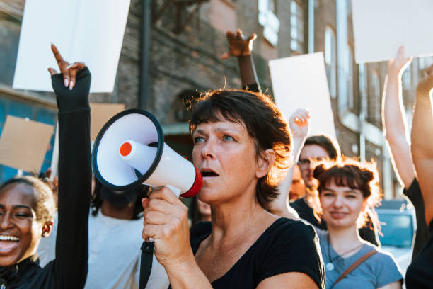 Feminist with a megaphone at a protest Feminist with a megaphone at a protest striker stock pictures, royalty-free photos & images