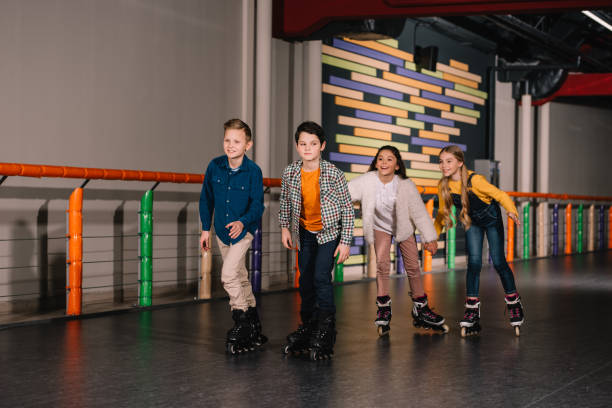 Group of friends in roller skates training together Group of friends in roller skates training together roller rink stock pictures, royalty-free photos & images