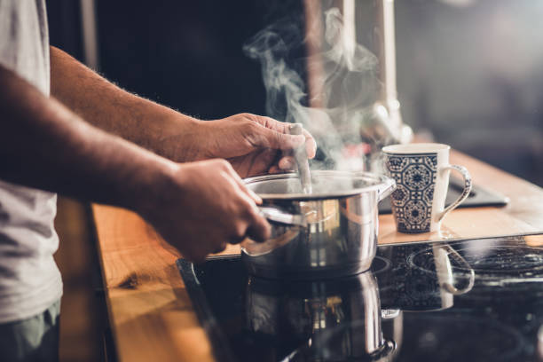 istock Close up of unrecognizable man stirring soup in a saucepan while making lunch in the kitchen. 1126066936