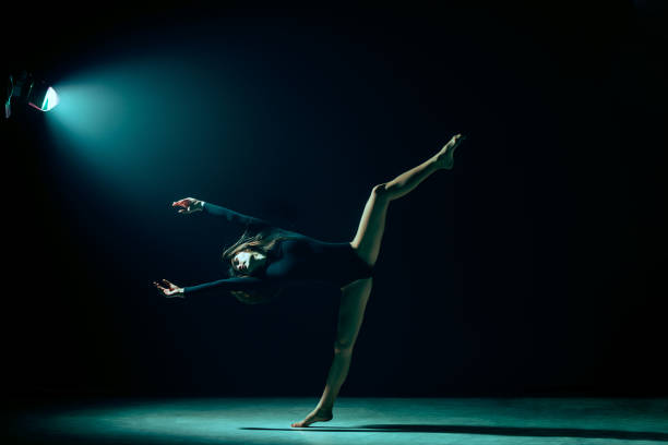 istock Young female ballet dancer on neon lights studio background. 1126070314
