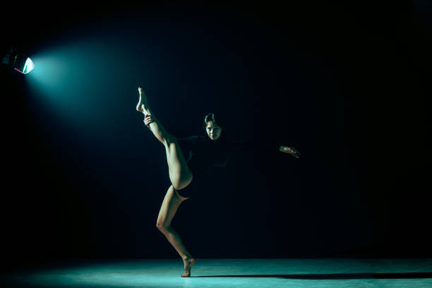 istock Young female ballet dancer on neon lights studio background. 1126070318