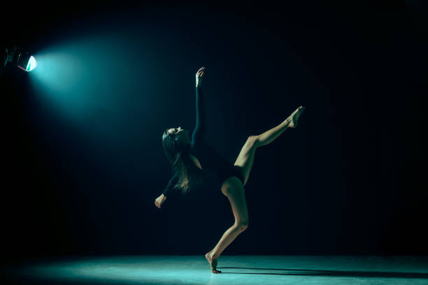 istock Young female ballet dancer on neon lights studio background. 1126070320