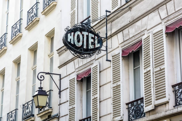 винтажный знак скромного отеля в старом здании с уличным светом периода в париже. - hotel front стоковые фото и изображения