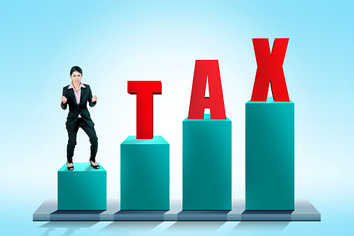 Excited asian business woman standing with Taxes text on 3D graphic. Taxes concept