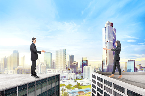 Asian business people standing on different rooftop with cityscapes background