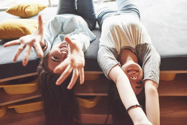 istock Two beautiful young twins sisters spending time together with pillows. Siblings having fun at home concept 1126072559