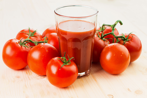 Glass of tomato juice with tomatoes on wooden background, Healthy lifestyle concept.