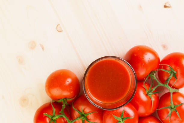 Glass of tomato juice with tomatoes on wooden background, Healthy lifestyle concept. Copy space for text. View from above.