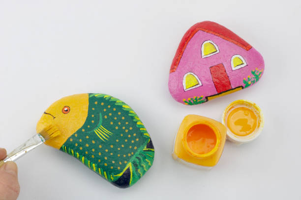 istock two multicolored painted stones as fish and as home  isolated on white background 1126074355
