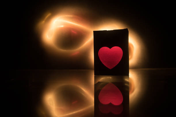 istock Blurred neon heart icon on a dark background. Copy space with red bright colorful heart on black background 1126074402