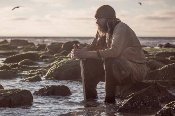 An individual viking warrior in action on a beach at the water's edge