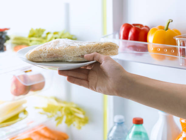 istock Woman opening the fridge and taking a fresh sandwich 1126076299