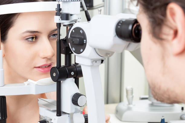 Young woman having an slit-lamp eye test in ophthalmology clinic High technology concept health for eyes care - The optician ophthalmology doctor optometrist in the eyes clinic using a binocular slit-lamp to a young woman for an eye control myopia stock pictures, royalty-free photos & images