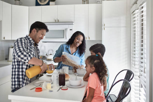 istock Smiling family having breakfast in kitchen at home 1126081161