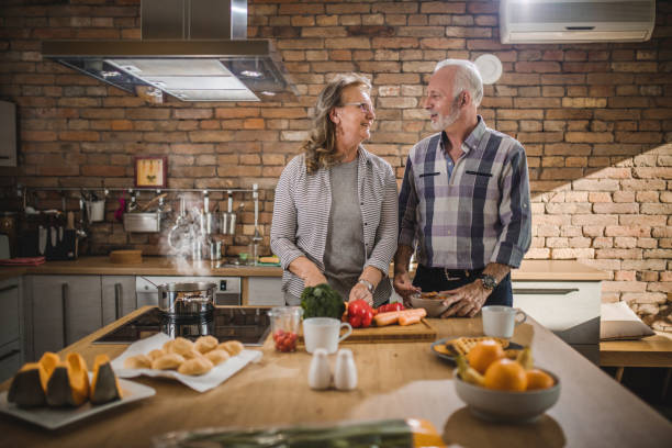 istock Happy mature couple communicating while preparing meal in the kitchen. 1126085340