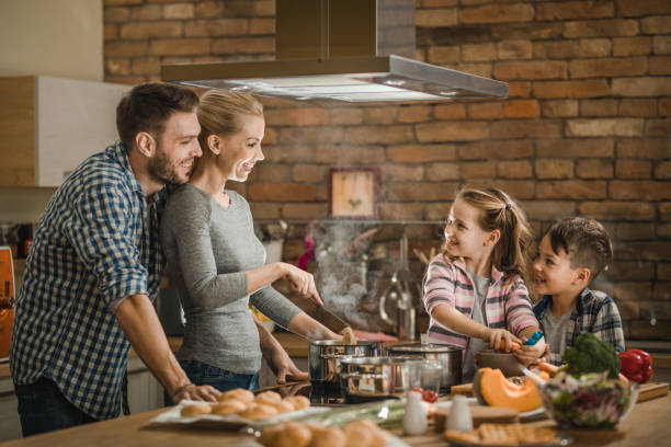 istock Happy family cooperating while making lunch in the kitchen. 1126088658