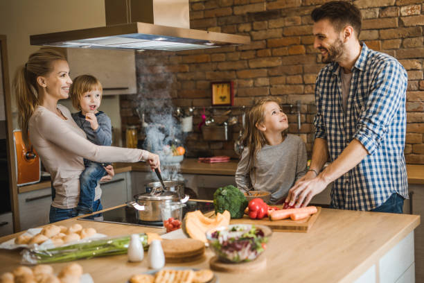 istock Young smiling parents enjoying while preparing lunch with their kids in the kitchen. 1126088767