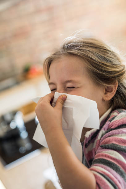 istock Small girl blowing her nose into a napkin. 1126088794