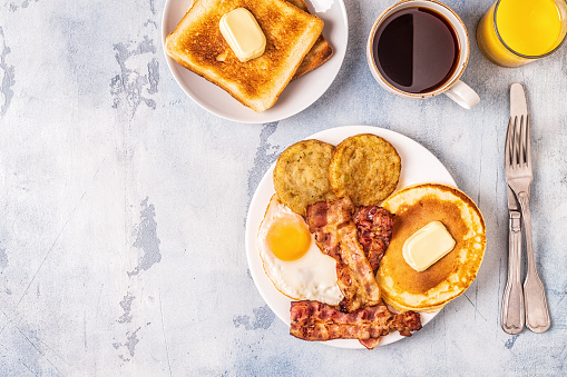 Healthy Full American Breakfast with Eggs Bacon Pancakes and Latkes, top view.