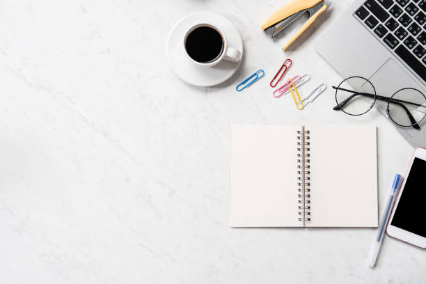 istock Stylized marble office working desk with smartphone, laptop, glasses and coffee, workspace design, mock up, topview, flatlay, copyspace, closeup 1126089986