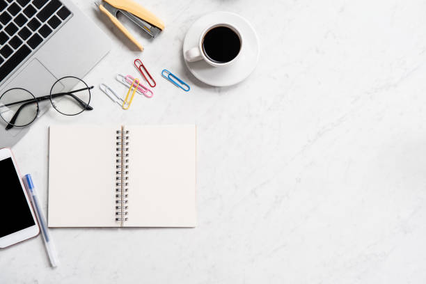 istock Stylized marble office working desk with smartphone, laptop, glasses and coffee, workspace design, mock up, topview, flatlay, copyspace, closeup 1126090015